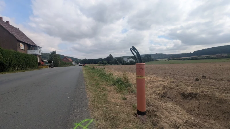 An der Bruchstra&szlig;e in Langenholzhausen wird in K&uuml;rze eine der zehn neuen Laternen angebunden. Ein Fachunternehmen ist bei der Arbeit. Im Vordergrund sieht man die Schlaufe eines Stra&szlig;enbeleuchtungskabels. - &copy; Gemeinde Kalletal