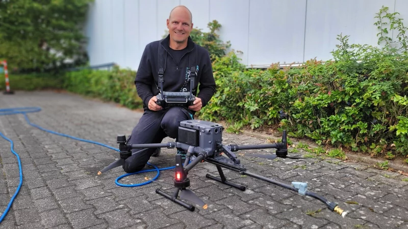 Oliver Dreweskracht und seine Drohne: Mit vier Rotoren und einer Düse kann sie bis zu 1000 Quadratmeter Fläche pro Tag putzen. - © Katrin Kantelberg