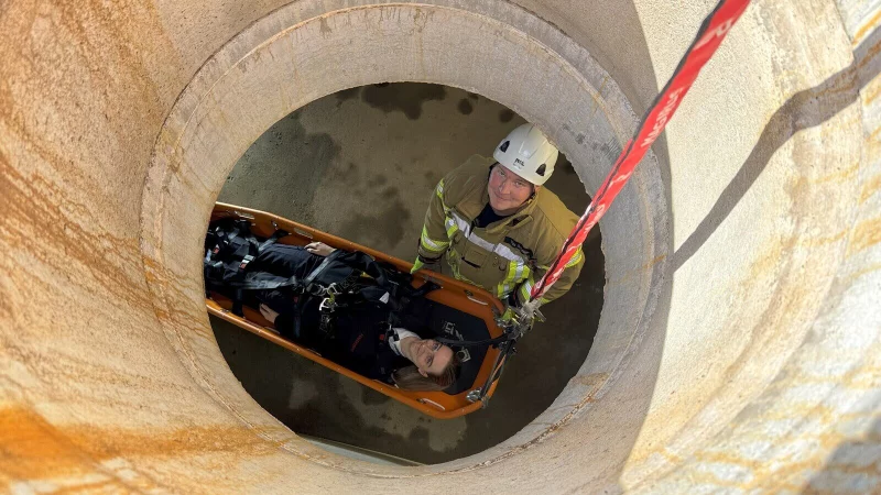 Lea Spellmeier wird über eine Schleifkorbtrage mithilfe von Tim Ortmann aus der Kanalisation ans Tageslicht gezogen. - © Sven Kienscherf