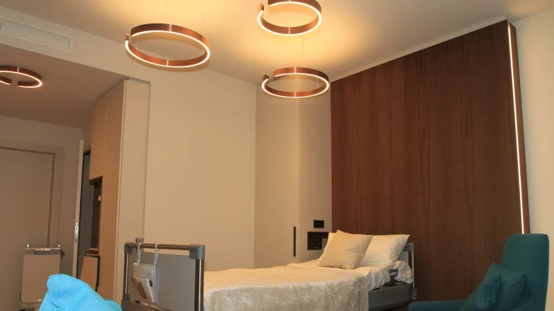 Eines der Musterzimmer auf der Privatstation. Die mit Rillen verschönerten Holzoberflächen hinter dem Bett kommen weg. - © Archivbild: Martin Hostert