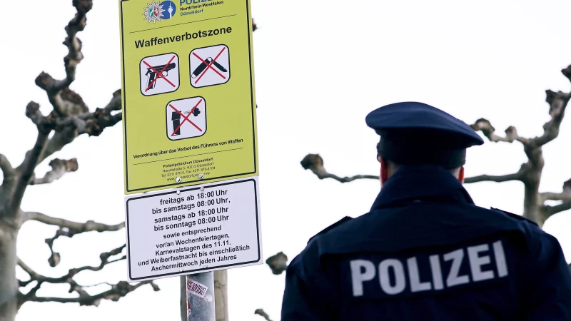 Ein Polizist kontrolliert die Hinweisschilder zur Waffenverbotszone. Auch am Bielefelder Hauptbahnhof wird eine solche jetzt eingerichtet. - © David Young/dpa