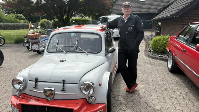 Dieter Hebrock in Rennfahrer-Montur an seinem Fiat Abarth, den er seit drei Jahrzehnten fährt. - © Jan Schillmann