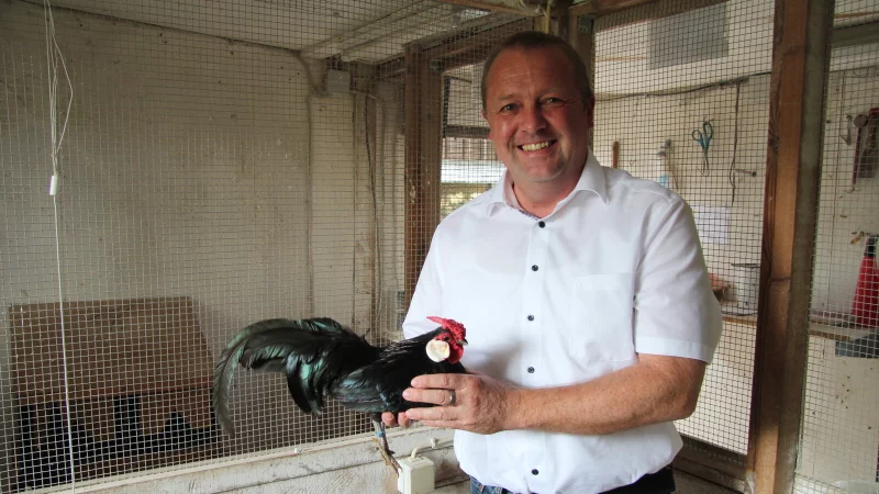 B&uuml;rgermeister Mario Hecker im H&uuml;hnerstall an seinem Elternhaus in Waterloo. Hier hat er jahrzehntelang selbst Gefl&uuml;gel gez&uuml;chtet. Mittlerweile fehlt ihm die Zeit. Sein Vater unterst&uuml;tzt ihn deshalb. - &copy; Nadine Uphoff