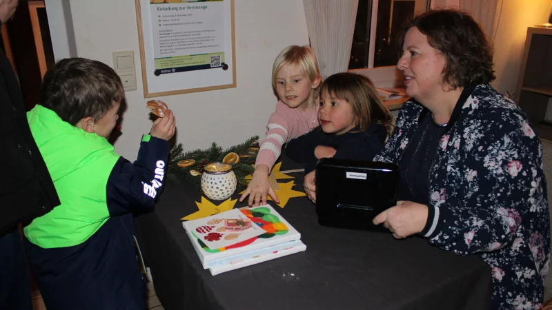 Am Tisch der Kita Sternschnuppe in Bega verhandeln Erzieherin Simone Pl&ouml;ger (von rechts), Luisa und Elisa die Preise f&uuml;r die Bilder. - &copy; Kyrill von Matuschka