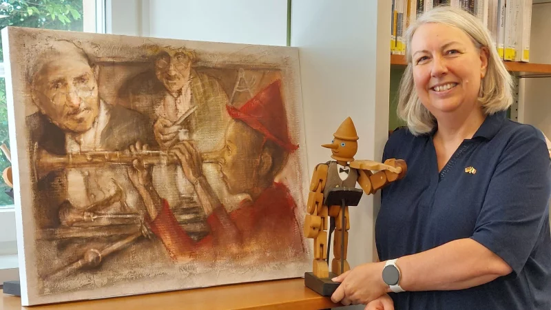 Elke Neuhaus von der Deutsch-Italienischen Gesellschaft Lippe-Detmold präsentiert Exponate der Ausstellung „Zu den Klängen von Pinocchio“. - © DIG Lippe-Detmold