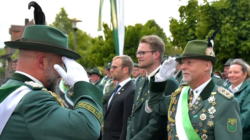 Oberst Markus Schantz (links) meldet J&ouml;rg Kleemann den Gro&szlig;en Zapfenstreich, daneben Fabian Stellmacher, Vorsitzender des Sch&uuml;tzenkreises Lippe und B&uuml;rgermeister Borris Ortmeier. - &copy; Rudi Rudolph