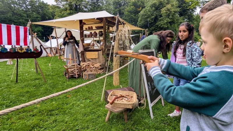 Der fünfjährige Tom Büscher probiert sich an der Armbrust, neben ihm wartet die neunjährige Vaniya Hosseini geduldig, dass sie an der Reihe ist. - © Yvonne Glandien