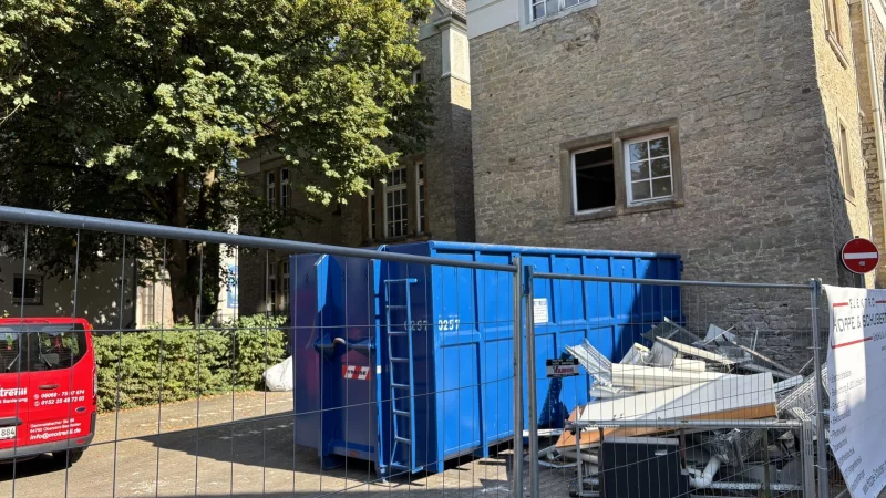 Ein Container für entkerntes Material steht vor dem Anbau auf der Rückseite des historischen Rathauses. Dieses Gebäudeteil, das aus den 1960er Jahren stammt und nicht unter Denkmalschutz steht, wird in Kürze abgerissen. - © Thomas Reineke
