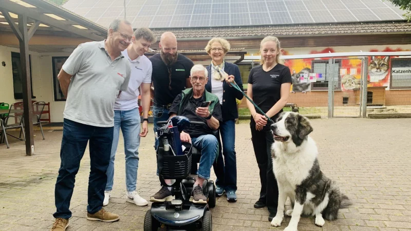 Helmut Tiekötter (Mitte) verfolgt per Handy-App die Stromproduktion auf dem Bielefelder Tierheimdach. Mit dabei, v.l.: Marcus Michels, Nico Kozlik, Heinrich Stückemann, Ulrike Graeser, Anjuli Barber und Hund Bella. - © Ivonne Michel