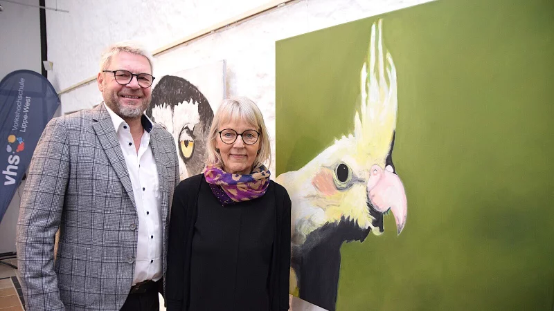 B&uuml;rgermeister Peter Heepmann er&ouml;ffnet die Ausstellung von Marie-Anna Fl&uuml;chter-Steffen im B&uuml;rgerhaus. Beide stehen vor einem der Lieblingsbilder der K&uuml;nstlerin, einem Nymphensittich, der gute Laune ausstrahlt. Foto: Karin Prignitz - &copy; Karin Prignitz
