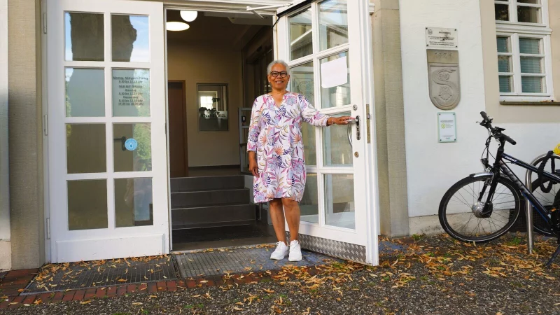 Malita Makoza h&auml;lt die T&uuml;r auf. Jahrelang hie&szlig; sie Menschen in Schlangen willkommen. - &copy; Gemeinde Schlangen