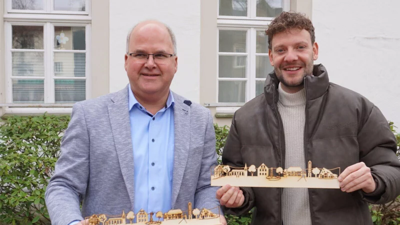 B&uuml;rgermeister Marcus P&uuml;ster (links) und Tourismusmanager Niklas Hecker pr&auml;sentieren die h&ouml;lzerne Silhouette. - &copy; Gemeinde Schlangen