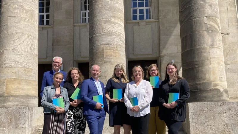 Jürgen Wannhoff (von links), Katharina Torwesten, Katrin Aissen, kaufmännischer Leiter Stefan Dörr, Kirsten Uttendorf, Leiterin Kommunikation und Marketing, Susanne Springer, Natascha Mamier und Emilia Ebert vor dem Landestheater, das das 200. Jubiläum feiern kann. - © Cordula Gröne