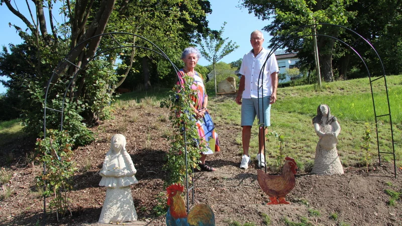 Künstlerin Renate Lübbing und Rainer Dubbert, Vorsitzender des Heimat- und Zieglervereins Talle, stehen in der neuen Märchenecke im Berggarten. - © Nadine Uphoff