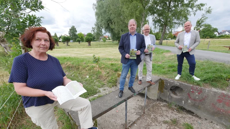 Annette Fischer, Autorin der "Lippischen Kulturlandschaften" zum Thema Flößwiesen in Schlangen, steht gemeinsam mit Dr. Stefan Wiesekopsieker (Lippischer Heimatbund, von links), Heinz Kriete (Heimatverein Schlangen) und Bürgermeister Marcus Püster auf den Resten eines Stauwehrs an den Niederen Knickwiesen. Im Hintergrund: eine ehemalige Flößwiese. - © Jost Wolf