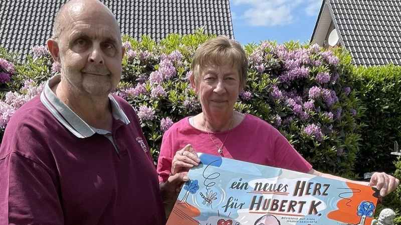 Hubert und Karin Knicker aus Bad Oeynhausen mit dem Plakat zum Comic „Ein neues Herz für Hubert K.“ - © Carolin Nieder-Entgelmeier