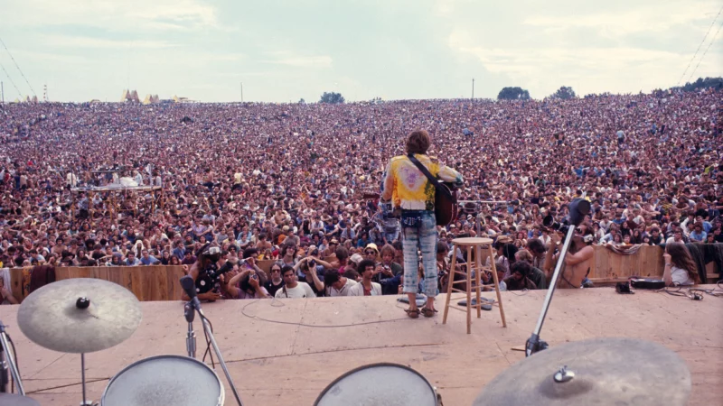 Das legend&auml;re Bild. Es zeigt den fast einsamen Musiker John Sebastian vor 500.000 Besuchern auf der "Woodstock-Wiese". - &copy; Henry Diltz