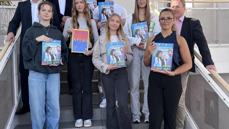 IHK-Abteilungsleiter Martin Raithel, IHK-Pr&auml;sident Volker Steinbach (hinten, von links) und Schulleiter Dr. J&ouml;rg Weber (rechts) stellen zusammen mit Sch&uuml;lerinnen und Sch&uuml;lern des Wirtschaftsgymnasiums am Dietrich-Bonhoeffer-Berufskollegs in Detmold den neuen Ausbildungsatlas OWL vor. - &copy; IHK Lippe