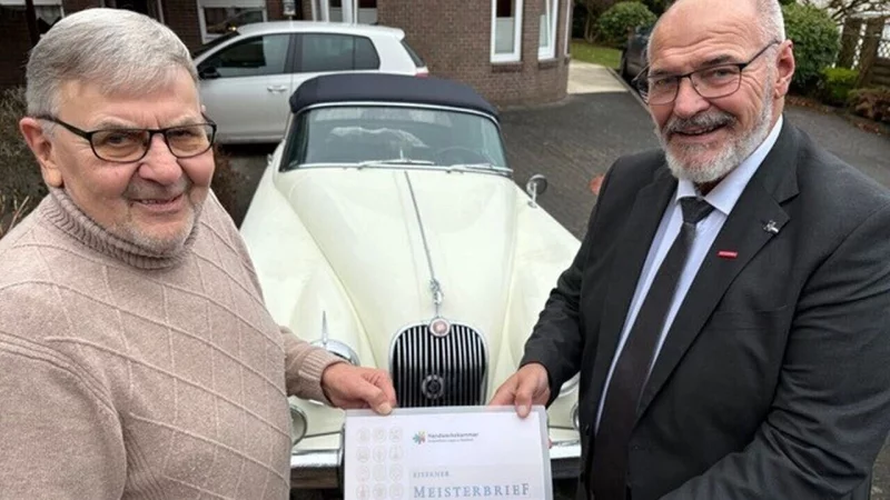 Jubilar Ottfried Stopka (links) und Kammerpräsident Peter Eul mit dem Eisernen Meisterbrief neben dem Oldtimer Jaguar XK 150. - © Michael Diekmann