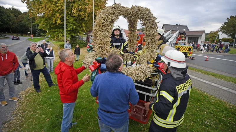 Mit Hilfe der Feuerwehr wurde die Erntekrone aufgehängt. - © Nicole Ellerbrake