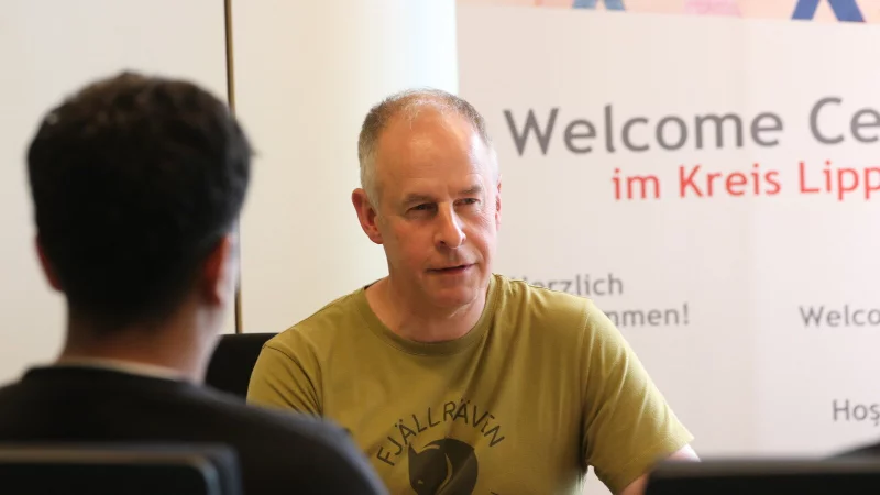 Matthias Eickhoff (KIM) ber&auml;t im Welcome Center zwei Kunden und geht mit ihnen das weitere Vorgehen in dem Fall durch. - &copy; Kreis Lippe