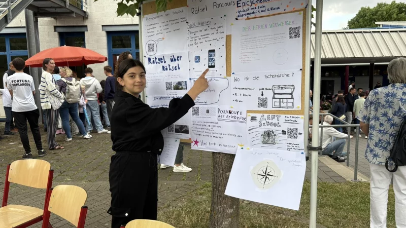 Siham Kako aus der 5a erkl&auml;rt den "R&auml;tsel-Parcours" beim Sommerfest. - &copy; Jan Schillmann