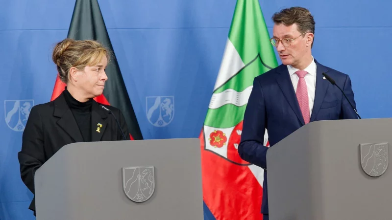 Mona Neubaur (Grüne), Wirtschaftsministerin von Nordrhein-Westfalen, und Hendrik Wüst, Ministerpräsident von Nordrhein-Westfalen (CDU), stehen bei der Pressekonferenz zum Investitionsprogramm des Landes auf dem Podium. - © Henning Kaiser/dpa