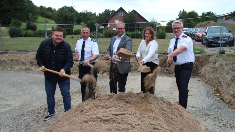 Projektleiter Florian Kenter (von links), Barntrups Feuerwehr-Chef Stefan Jakob, Bürgermeister Borris Ortmeier, Planerin Marina Klippenstein und Christian Meier, Einheitsführer in Sonneborn, machen den symbolischen ersten Spatenstich. Im Hintergrund ist schon die Fläche für den Anbau zu sehen. - © Nadine Uphoff
