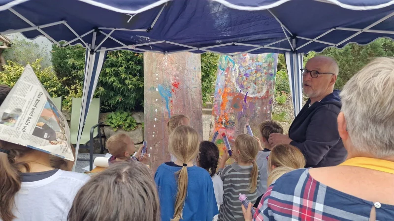 K&uuml;nstler Kurt Trometer zeigt den Kindern, wie sie mit den Farbspritzen umgehen m&uuml;ssen. - &copy; Nadine Uphoff