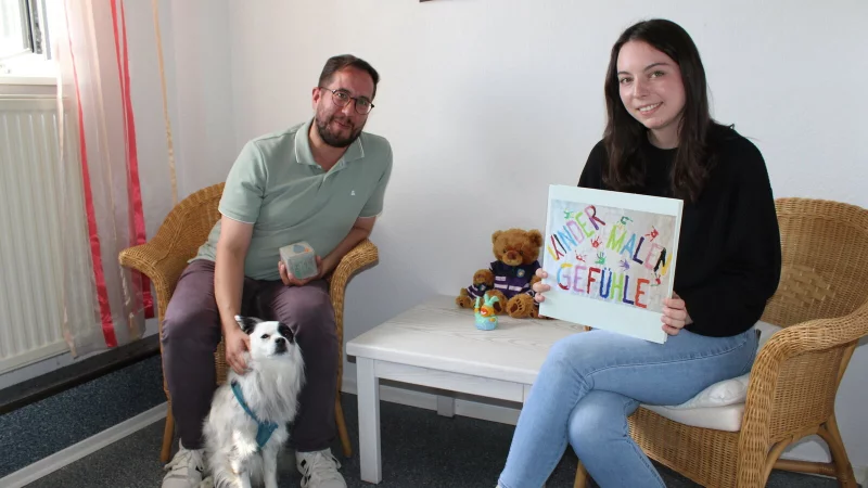 Ein Raum für Trauer aller Art: Marcel Nerger (links) und Justine Leubecher arbeiten seit einem halben Jahr ehrenamtlich für den Verein Courage. Hündin Bella hilft, das Eis zu brechen. Auch Kreativität, wie im Buch "Kinder malen Gefühle", ist ein wichtiges Werkzeug. - © Annika Langhagel