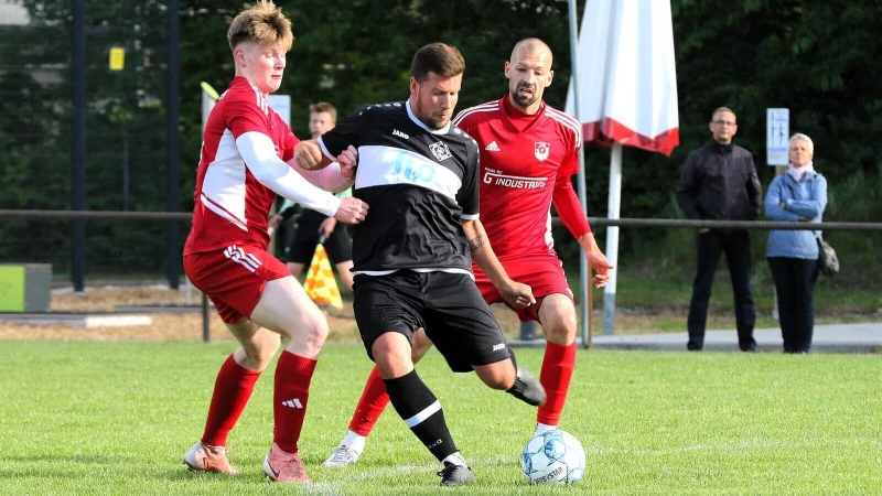 Helpups Marc Schubert (Mitte) kontrolliert den Ball gegen die Bexterhagener Frederik Rußkamp (links) und Moritz Gromann. - © Oliver König