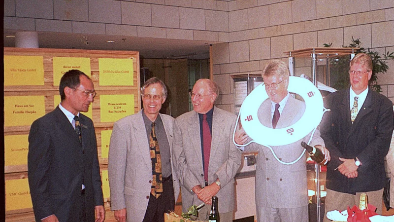 B&uuml;rgermeister Gerhard Kleemann (4. von links) und der Millauer Vereinsvorsitzende Claude Lacombe (3. von links) weihen im Jahr 2000 anl&auml;sslich des 25-j&auml;hrigen Partnerschaftsjubil&auml;ums das allererste von Verein AWB geschaffene Holzruderboot Millau f&uuml;r den Kurparksee ein. - &copy; Friedrich-Wilhelm Schulte