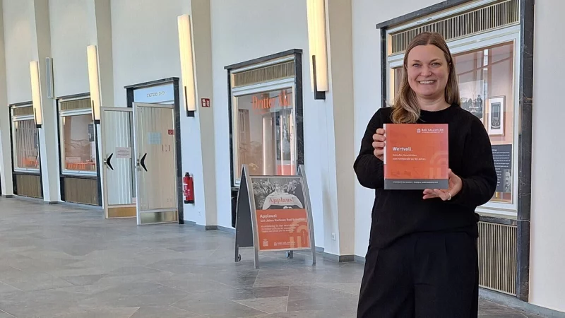 Stadtarchivarin Sonja Beinlich pr&auml;sentiert in der Wandelhalle die erste Katalogauflage zur Ausstellung Wertvoll. Salzufler Geschichten zum Kriegsende vor 80 Jahren. - &copy; Stadt Bad Salzuflen