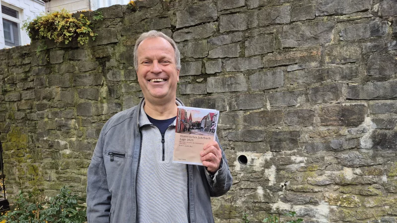 Dr. Hans C. Jacobs zeigt die neue Ausgabe der Lagenser Jahreschronik. - © Lorraine Brinkmann