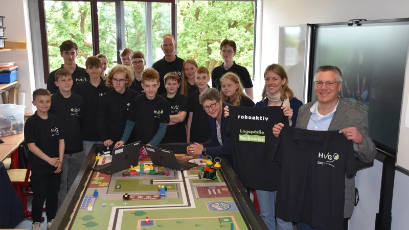 Gemeinsam für mehr Technikkompetenz: Die Schüler der Roboter-AG des Hermann-Vöchting-Gymnasiums, AG-Leiter Gunnar Jürgens auf der Haar (hinten, Mitte) und Schulleiter Michael Hanke (vorne rechts) freuen sich über die Unterstützung von Dr. A. Heinrike Heil (vorne, 3. von rechts) und Stefanie Beckmeier (vorne, 2. von rechts). - © Hermann-Vöchting-Gymnasium