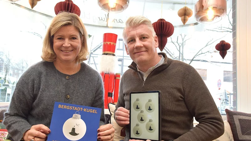 Cerrin Wehrmann-Ristau von der Buchhandlung Blume und der Präsident des Rotary Clubs Detmold-Oerlinghausen, Marcel Klöpping, präsentieren die Kugel mit dem ersten Bergstadt-Motiv. Foto: Karin Prignitz - © Karin Prignitz