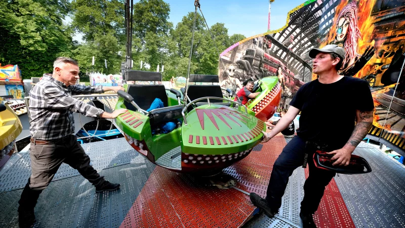 Marktmeister Manuel Schneider (links) packt in G&uuml;tersloh beim Aufbau vom "Steamer", einer Art Breakdance, der auch in die H&ouml;he schnellen kann, mit an. Betreiber Geron Langhoff geht ihm zur Hand. - &copy; Andreas Fr&uuml;cht