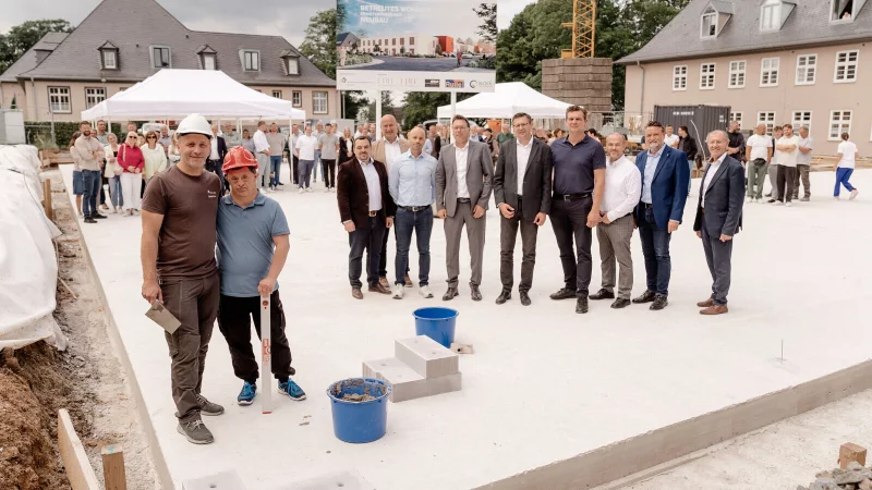 CWS-Bauleiter Daniel Krein und sein "inoffizieller Bauleiter" (vorne links) legten in Anwesenheit vieler "Offizieller" den symbolischen Grundstein f&uuml;r das inklusive Wohnprojekt. - &copy; CWS OWL