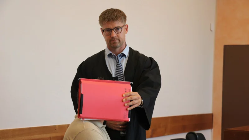Verteidiger Nikolai Odebralski hält schützend einen Aktenordner vor das Gesicht seines Mandanten. Der 28-Jährige räumt alle Anklagevorwürfe ein. - © Janet König