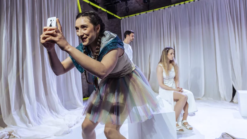 Jonas Schwester Billie (Maja Grahnert; im Vordergrund) macht diesen auf Social Media ber&uuml;hmt. Deren Eltern (Alexandra Riemann, Sebastian Zumpe) wirken machtlos und &uuml;berfordert. - &copy; Landestheater Detmold/Jochen Quast