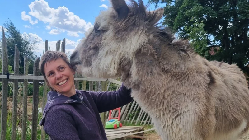 Beata Langkau freut sich &uuml;ber einen Schmatzer von Esel "Huckepack". - &copy; Kirsten Fuhrmann