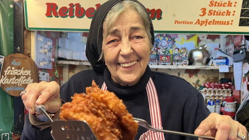 Ursula Parpalioni serviert den Kunden am Stand ihre frisch gebackenen Reibekuchen. Die 70-J&auml;hrige ist ein Urgestein des Weihnachtsmarktes. - &copy; Nicole Sielermann