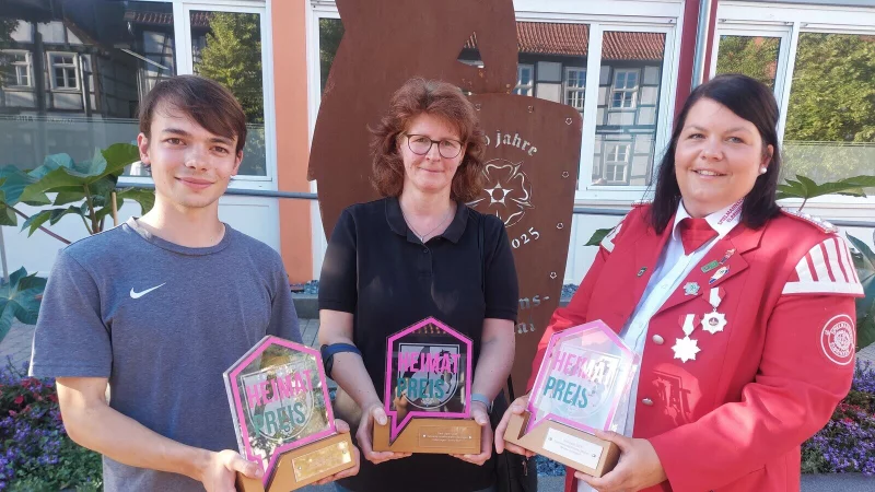 Lukas Gansler (von links, Leiter des Kellertreffs der Kolpingsfamilie Lügde), Anke Weber (Schriftführerin des Heimat- und Verkehrsvereins Falkenhagen) und Lena Wolff (Vorsitzende des Spielmannszuges Elbrinxen) haben die Heimatpreise für ihre Vereine entgegengenommen. - © Michaela Weiße