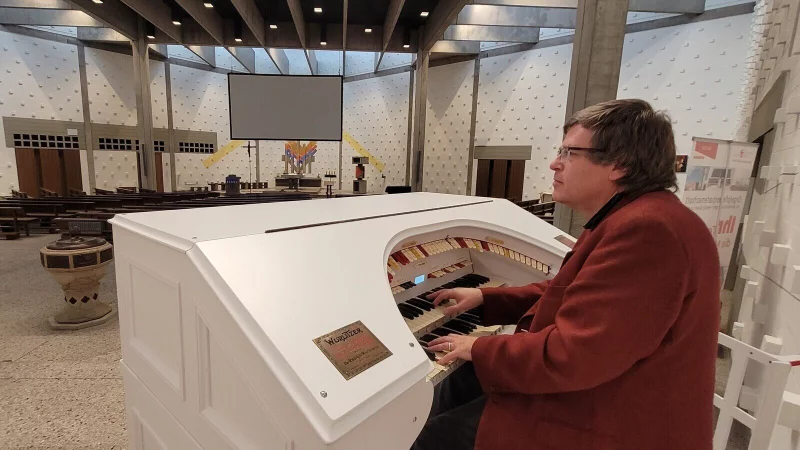 Gregor Schwarz lädt zum offenen Singen in die Kirche ein. Die Texte zu den populären Liedern gibt es passend auf großer Leinwand. - © Katrin Kantelberg