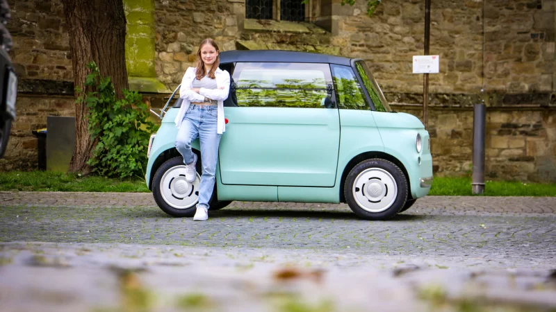 Lara Boscher vor ihrem türkisfarbenen Topolino. Den kleinen E-Flitzer möchte die 17-jährige Herforderin nicht missen - er gibt ihr ein Gefühl von Selbstständigkeit. - © Daniel Salmon