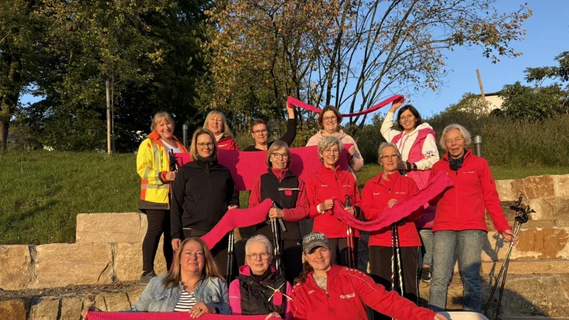 Die Taller Walkinggruppe strickte im vergangenen Sommer zahlreiche, meterlange pinke Schals. Gemeinsam mit Sabine Mirbach (Brustkrebspatientin) umwickeln sie die B&auml;ume des Berggartens in Talle. - &copy; Jan Schillmann