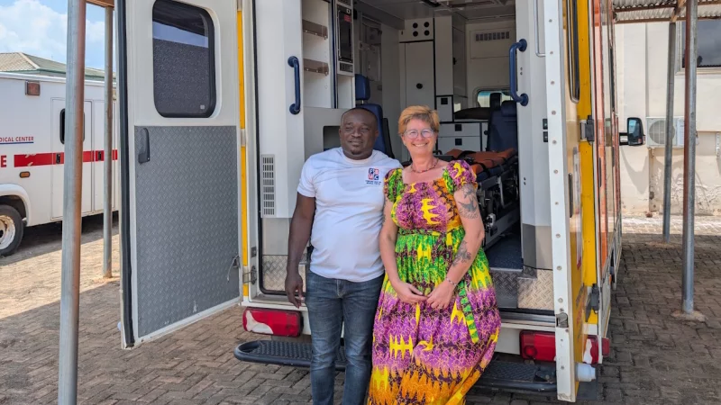 Friederike Saueressig und Richard Aboagye, Geschäftsführer des Frimpong-Boateng Medical Centers, stehen vor dem RTW, den die Notfallsanitäterin des Kreises in Lippe selbst gefahren ist. - © Marcus Saueressig