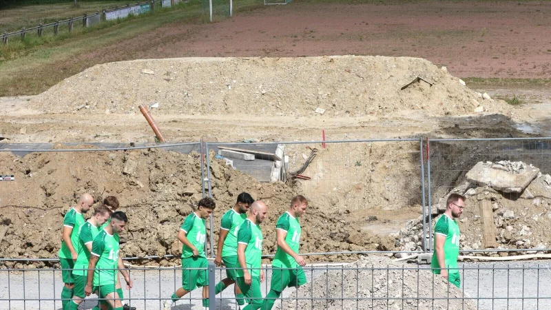 Vorbei an der größten Baustelle geht es für die Spieler der TuS Helpup zum Rasenplatz, hier entsteht das neue Sporthaus. Im Hintergrund ist der Hartplatz zu sehen. - © Oliver König