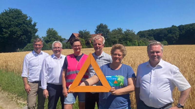 Hier könnte die Trasse langführen: Vlothos Bürgermeister Rocco Wilken, Landrat Jürgen Müller, Sarah Brodowski von den Landfrauen im Kreis Herford, Hermann Dedert, Voritzender des Landwirtschaftlichen Kreisverbandes Herford-Bielefeld, Stefanie Rothenstein, zweite Vorsitzende von Widuland sowie Herfords Bürgermeister Tim Kähler stehen vor einem Feld des Hofs Bohnenkamp. Dahinter liegt der Wald, den die Trasse durchschneiden könnte. - © Jobst Lüdeking