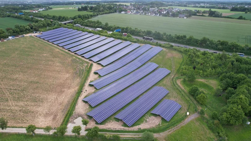 Das Luftbild zeigt die neue Photovoltaik-Anlage, die oberhalb von der A2 und links von der Ahmser Straße begrenzt ist. Von der Autobahn sind die Module wegen des Bewuchses entlang der Fahrbahn nicht zu sehen. - © Energiesysteme Groß GmbH & Co. KG